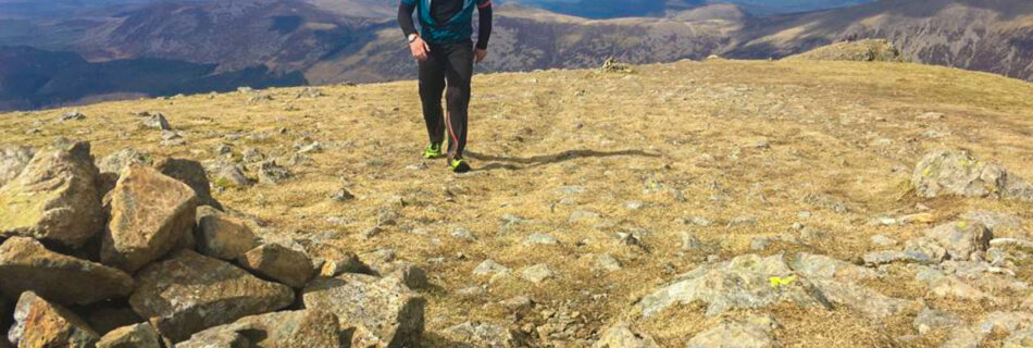 A young man running up a fell in the Lake District