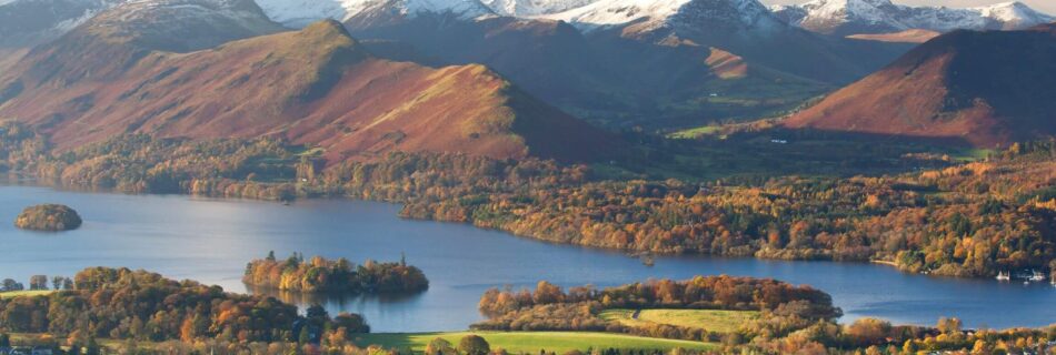 An aerial shot of Keswick town with Lake Derwent and fells in the background