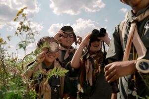 a group of scouts using binoculars and magnifying glasses