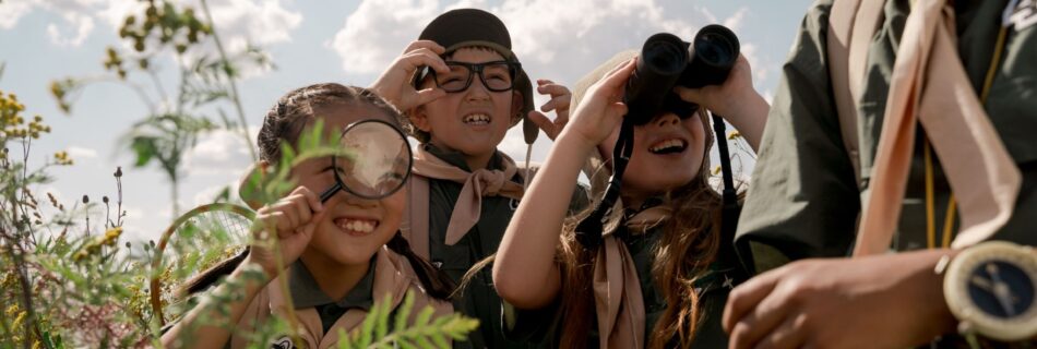 a group of scouts using binoculars and magnifying glasses