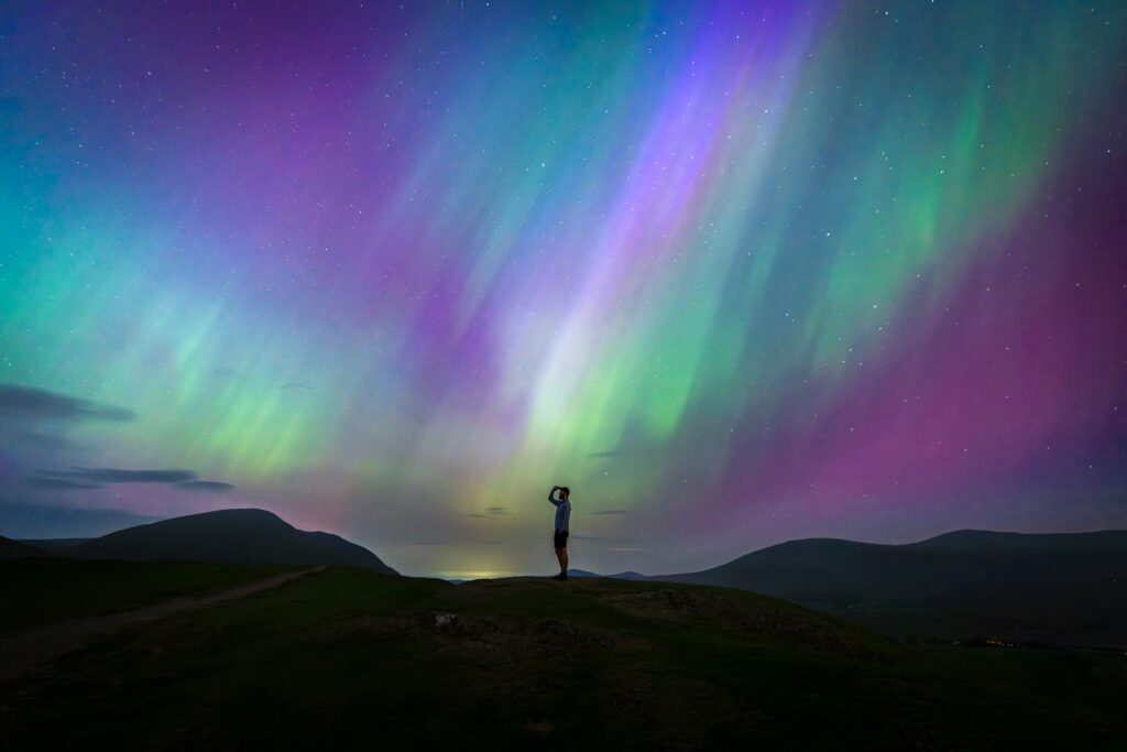 Multi coloured northern lights with a person silhouetted